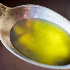 Łyżka z płynnym, żółtym olejem lnianym, który może pomóc w obniżeniu cholesterolu.