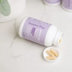 Inositol Plus - suplementy na poprawę komórek jajowych. Kilka kapsułek na wieczku i w butelce.