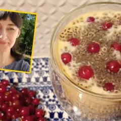 Kobieta uśmiecha się obok deseru z nasionami chia i czerwonymi porzeczkami. Pyszne i zdrowe śniadanie.