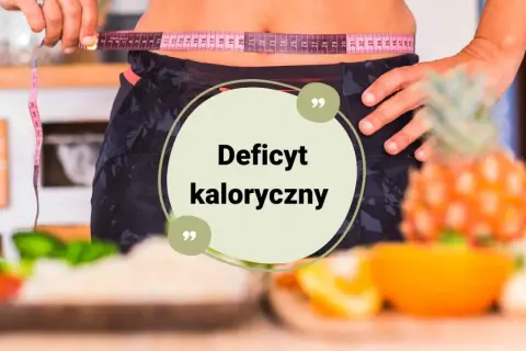 Osoba mierzy talię centymetrem, by dowiedzieć się, jak obliczyć deficyt kaloryczny. Na stole owoce i warzywa.