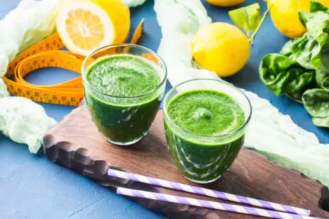 Zielone smoothie, cytryny i szpinak – idealne składniki na detoks organizmu. Miarka krawiecka sugeruje początek zdrowej przemiany.