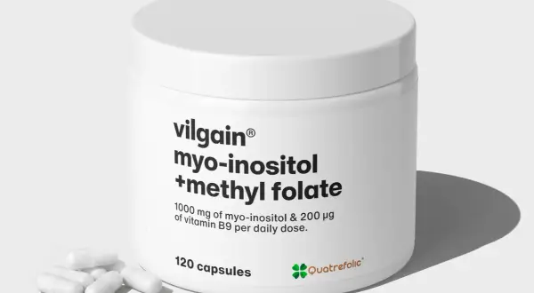 Biały słoiczek z suplementem diety zawierającym kwas foliowy metylowany, myo-inozytol i witaminę B9. Kilka kapsułek leży obok.