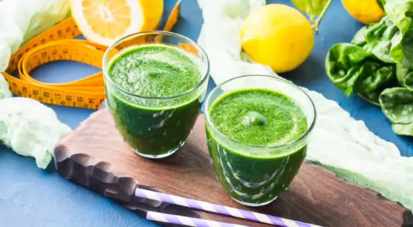 Zielone smoothie, cytryny i szpinak – idealne składniki na detoks organizmu. Miarka krawiecka sugeruje początek zdrowej przemiany.
