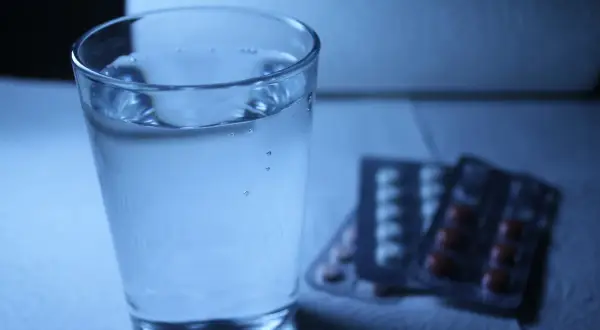 Szklanka wody obok opakowań leków. Czy to melatonina i alkohol, czy tylko złudzenie?