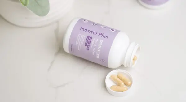 Inositol Plus - suplementy na poprawę komórek jajowych. Kilka kapsułek na wieczku i w butelce.