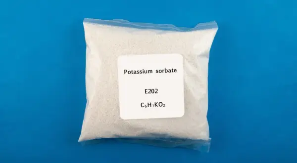Zagrożenia związane z sorbinianem potasu E202. Biały proszek w woreczku z etykietą "Potassium sorbate".