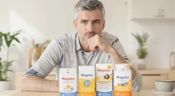 Mężczyzna zastanawia się nad wyborem suplementu. Węglan magnezu wchłanianie jest kluczowe dla zdrowia.