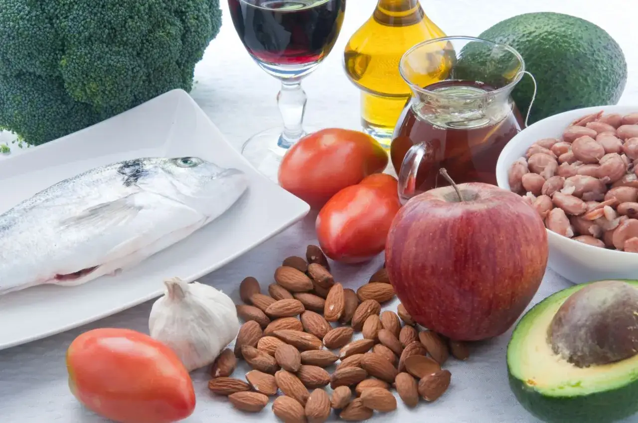 Zdrowe produkty, kt&oacute;re pomogą Ci dowiedzieć się, jak obniżyć LDL: ryba, migdały, awokado, jabłko, pomidory, czosnek, brokuły, oliwa z oliwek.